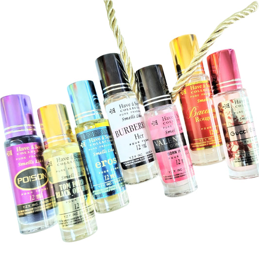 Collection of small perfume bottles with various designs and colors on a white background.